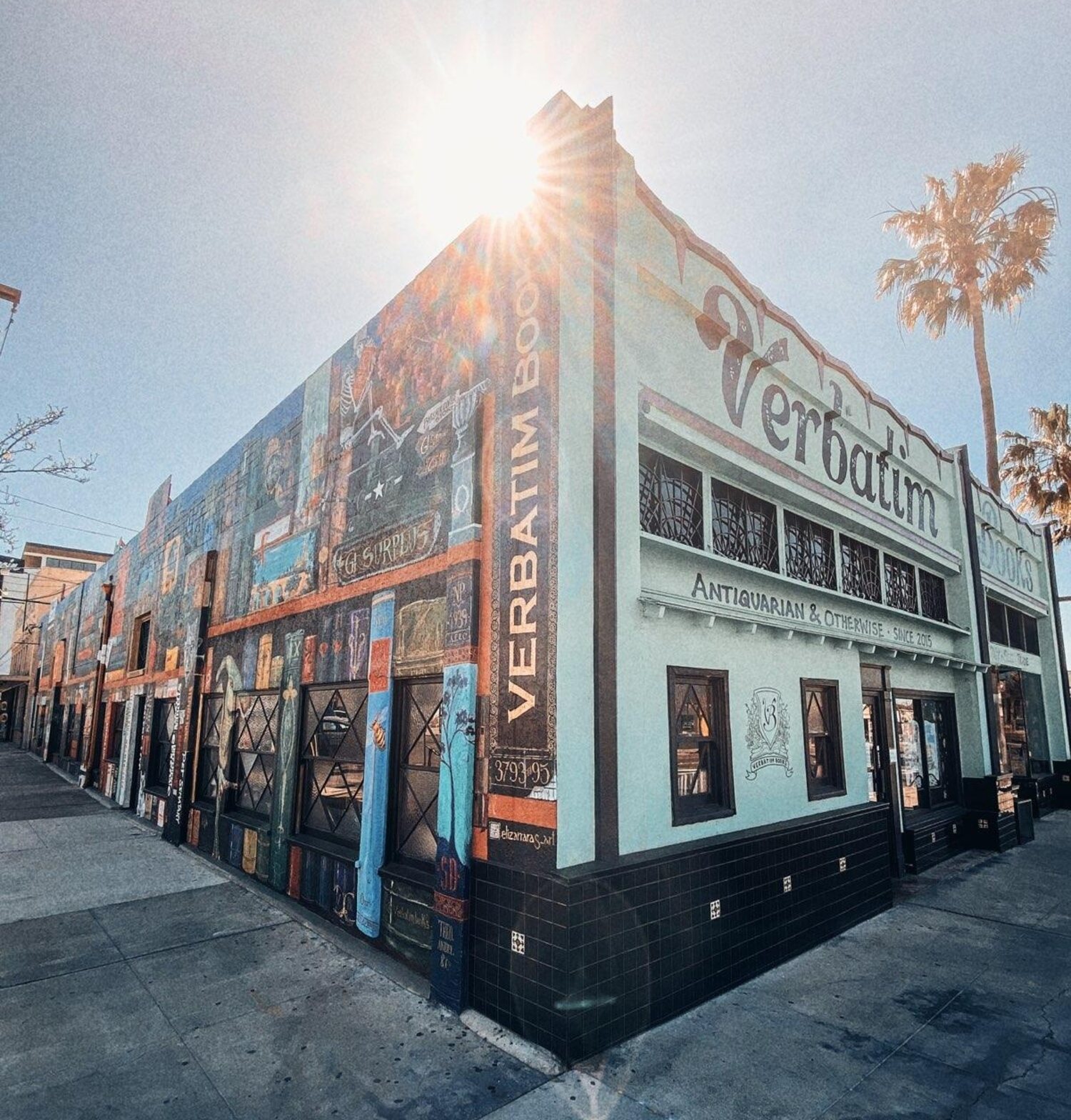 The teal-green Verbatim Books storefront at the corner of 30th Street and North Park Way at golden hour